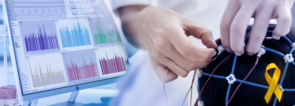 Specjalista zakłada czepek EEG z elektrodami na głowę pacjentki, w tle monitor z analizą widmową sygnału EEG, żółta wstążka Żółtego Września